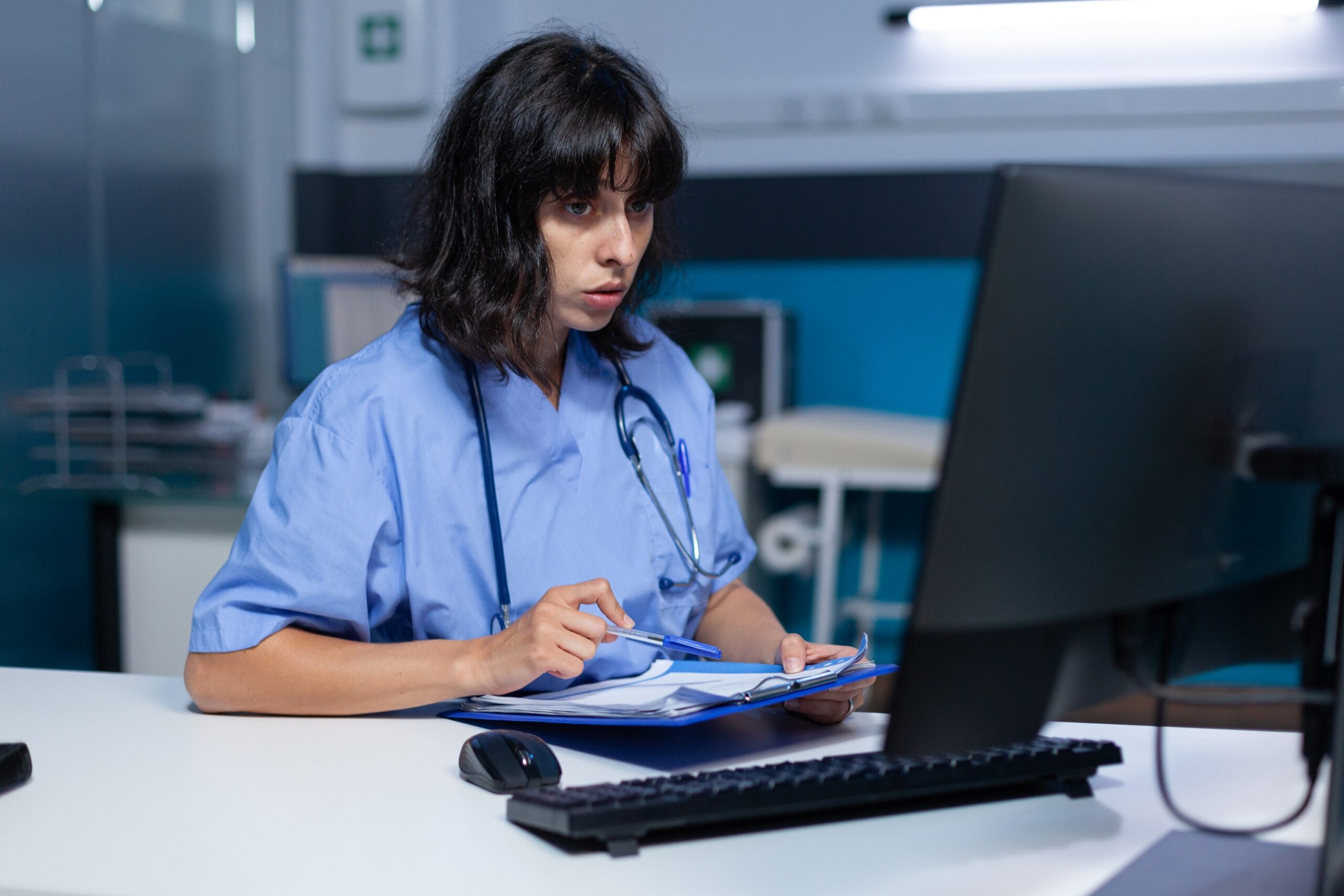 medical officer is computer working with checkup papers
